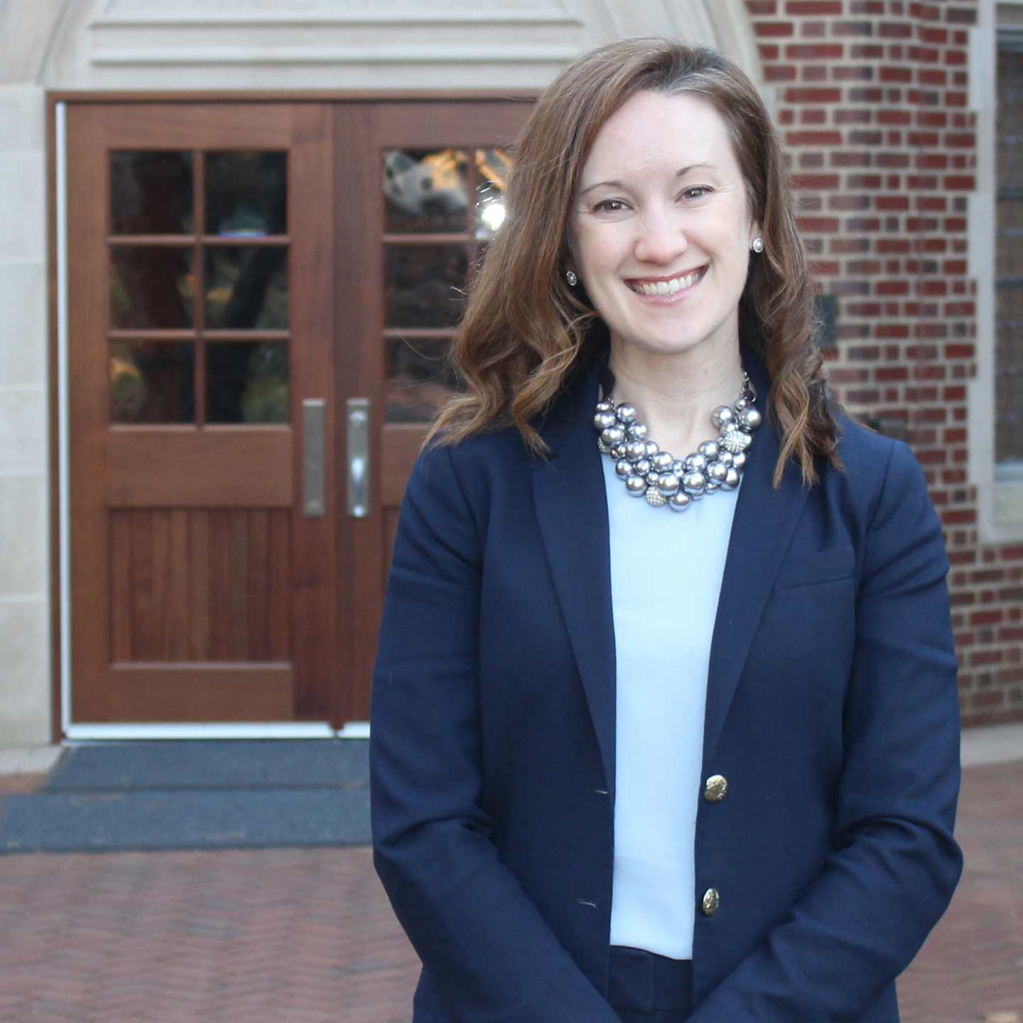 An environmental portrait of Katherine Groover standing in front of the Law school at the University of Richmond.