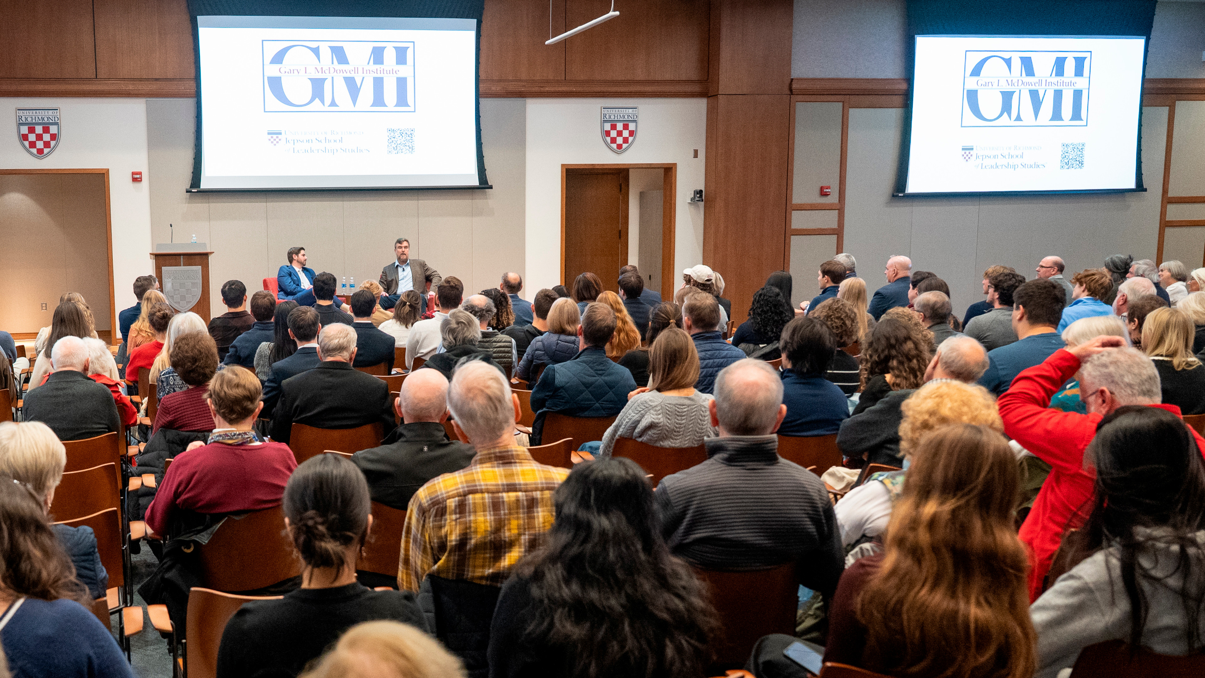 A photo of McDowell Institute discussion with Greg Lukianoff and Jepson professor Sam Director. The photo is shot from the back ofthe room, showing a full house for the conversation.