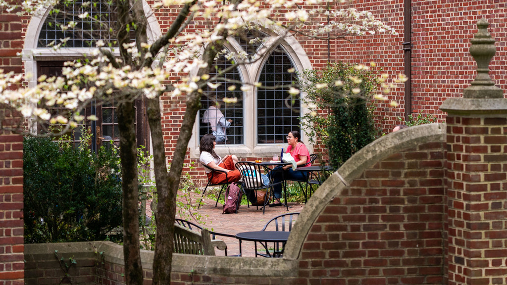 Cover image of the Dean's Report with two students sitting in the courtyard