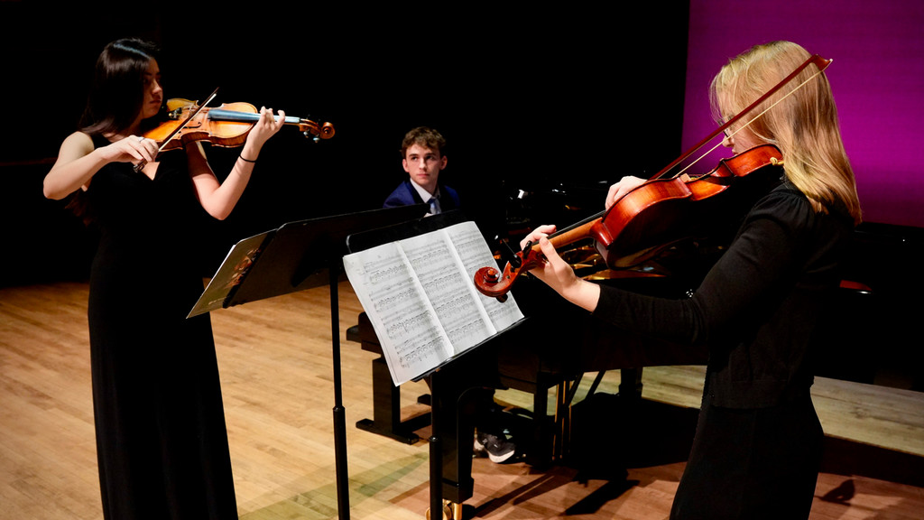a young chamber trio performs on stage