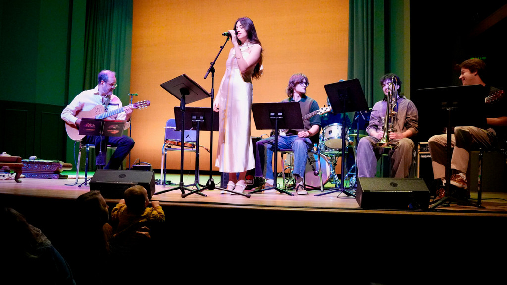 female vocalist performs on stage with a small Brazilian ensemble