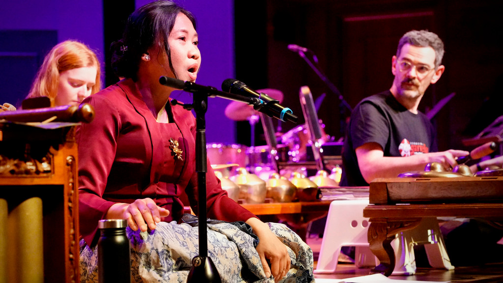 Gamelan ensemble performs on stage with vocalist