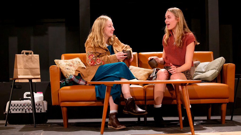Two women in conversation together on a sofa