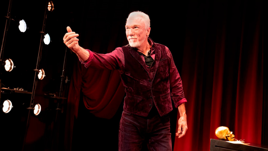Actor Patrick Page on stage reaching hand out