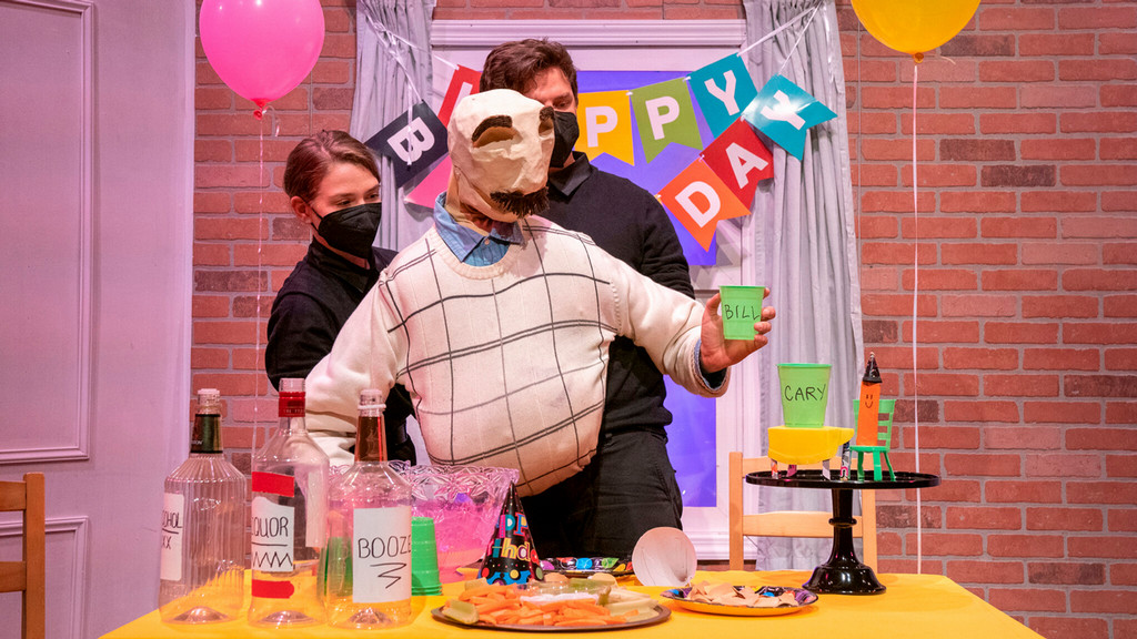 puppets and puppeteers performing on stage in a birthday party setting