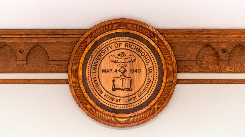 The University of Richmond seal carved into wood inside a campus building.