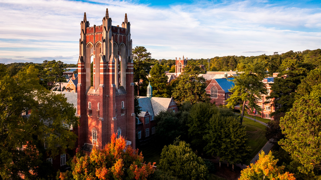 The tall brick tower of Boatwright Memorial Library among fall foliage.