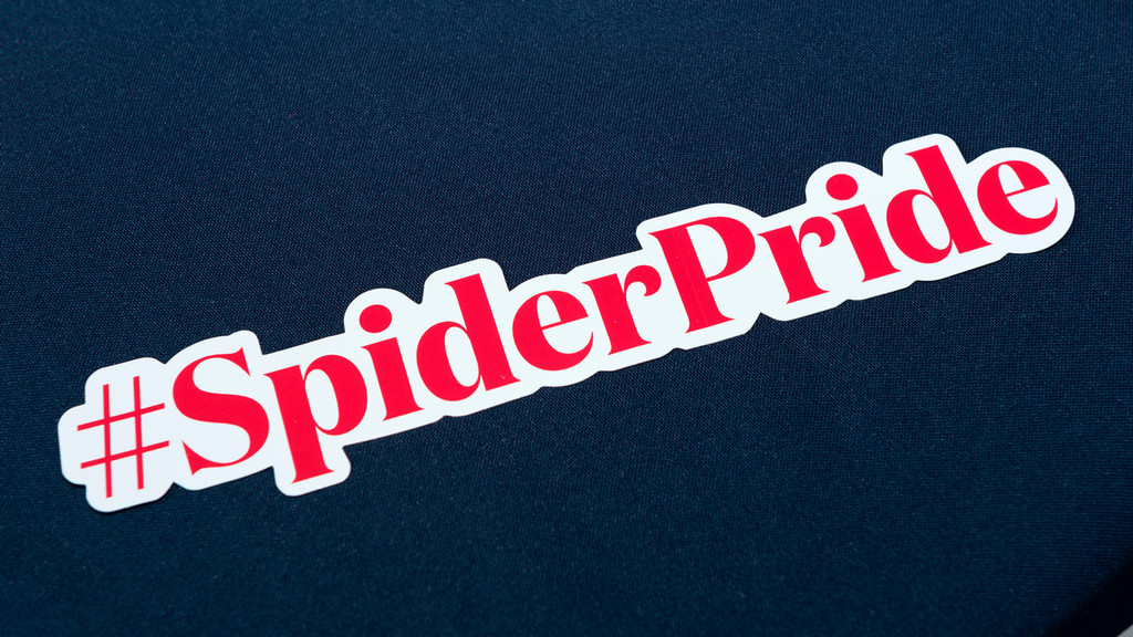 #SpiderPride sticker on a blue cloth background