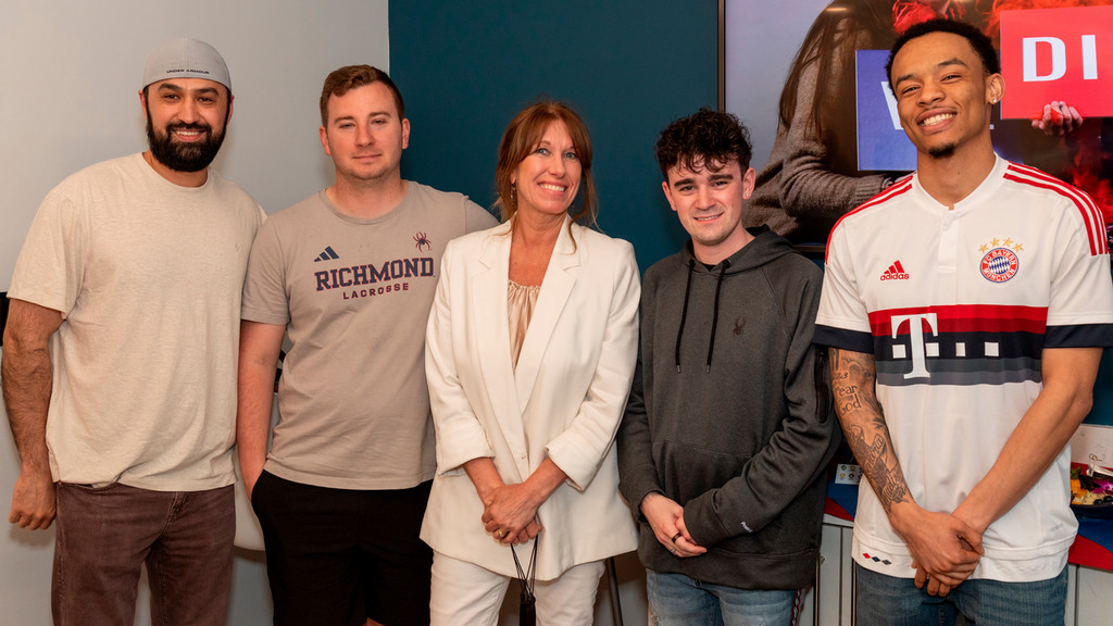 Five people in a line posing for a photo