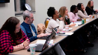 Students sitting in a classroom row, looking at the instructor