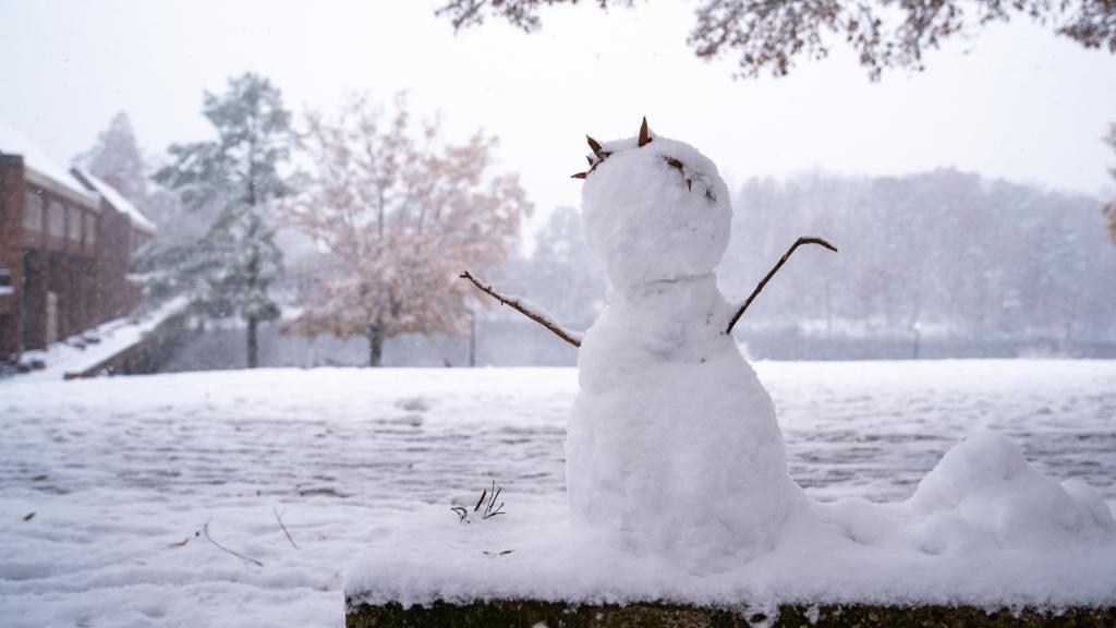 Snowman outside a brick building