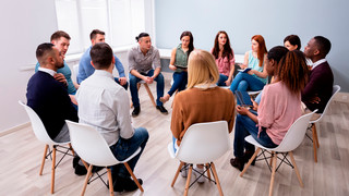 Group of people seated in a circle facing each other