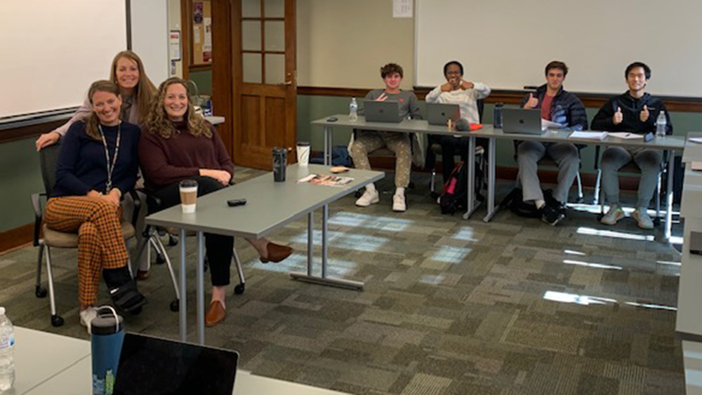 Students sitting at tables posing for a group shot