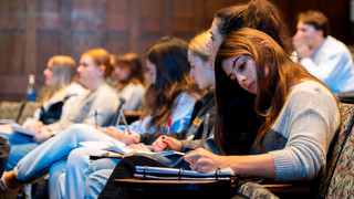 Student taking notes in classroom
