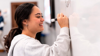 Student writing on whiteboard