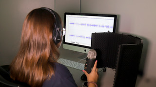 A student works with audio equipment on a computer at the technology studio.