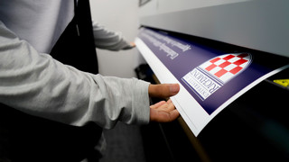 A student prints a large format poster on a campus printer.