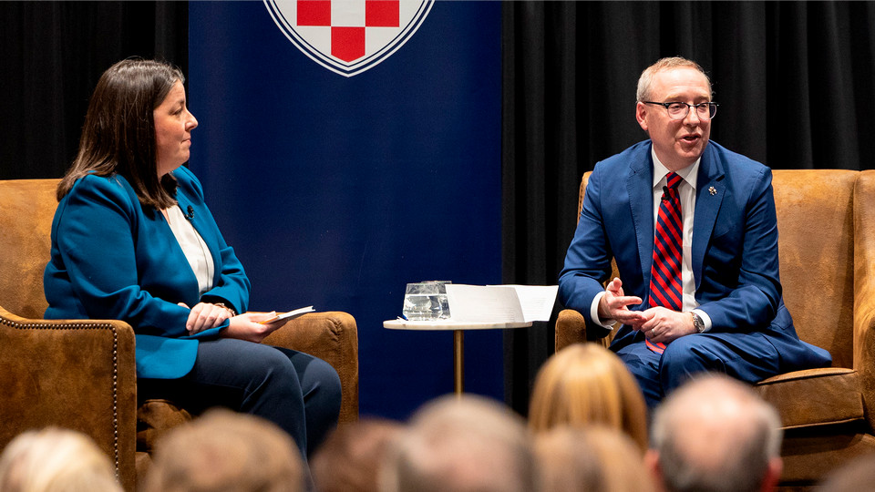 A photo of Martha Callaghan and presidentKevin Hallock in discussion on a stage at the University of Richmond.