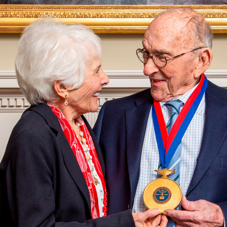 A photo of Carole and Marcus Weinstein looking at each other and smiling.