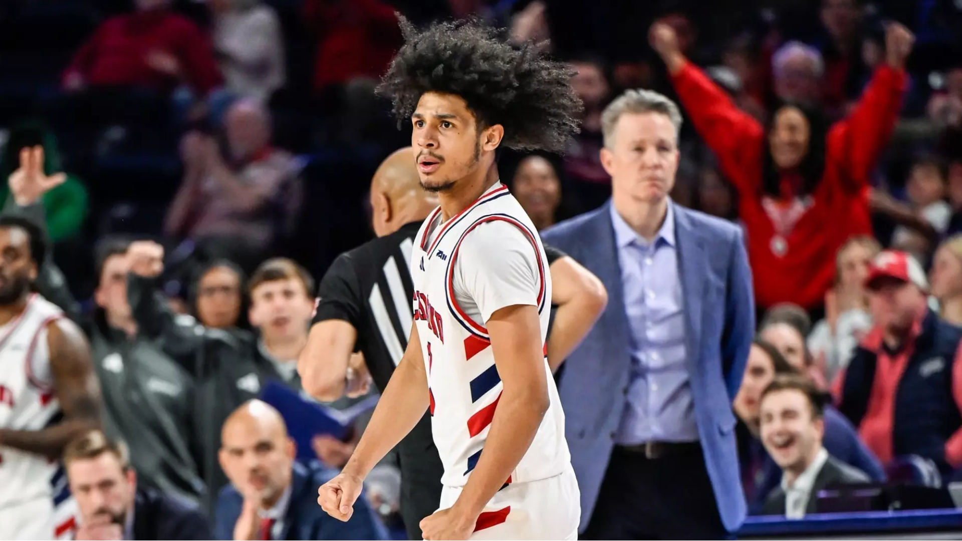 Aiden Argabright on the basketball court for the University of Richmond men's basketball team. Coach Chris Mooney is in the background.