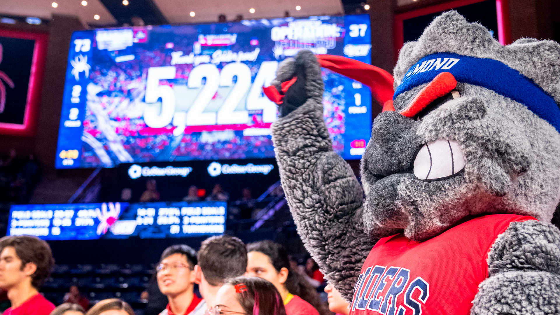 A photo of WebstUR at the University of Richmond women's basketball "code red" game, featuring the scoreboard with the total attendance count of 5,224 people.