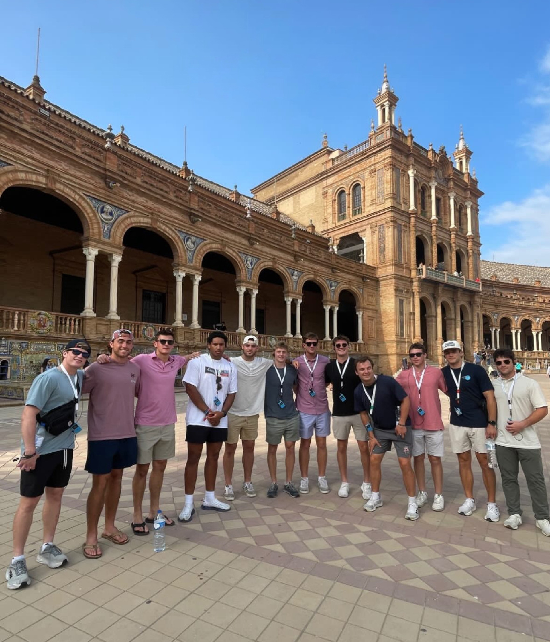 The men's lacrosse team posing for the camera, standing in a plaza in Lisbon Portugal.