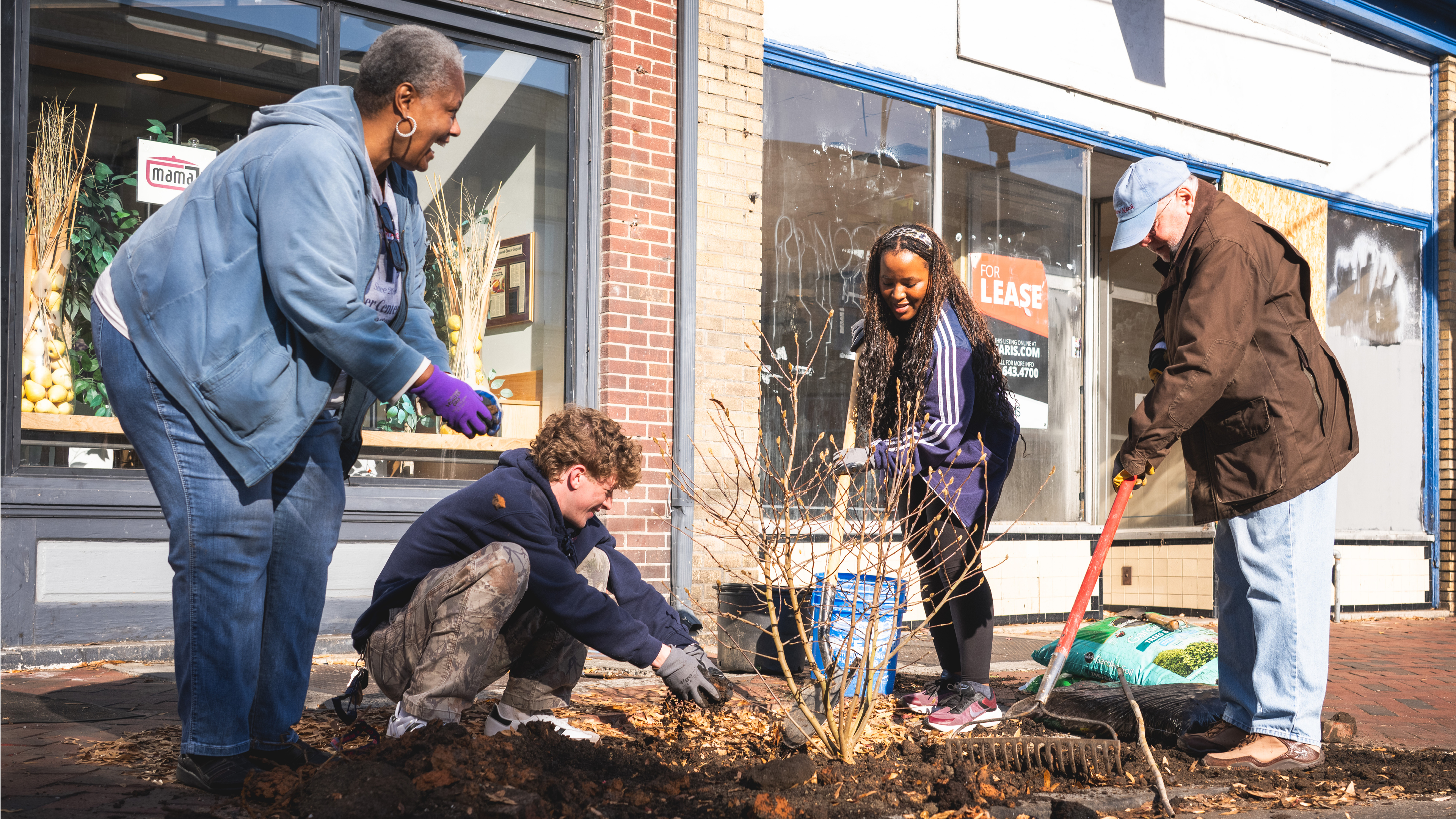 A photo of Historic Jackson Ward President Janis Allen with UR students Donovan Murray and Thuba Mnisi, and community member Laurance Wieder planting trees in downtown Richmond.