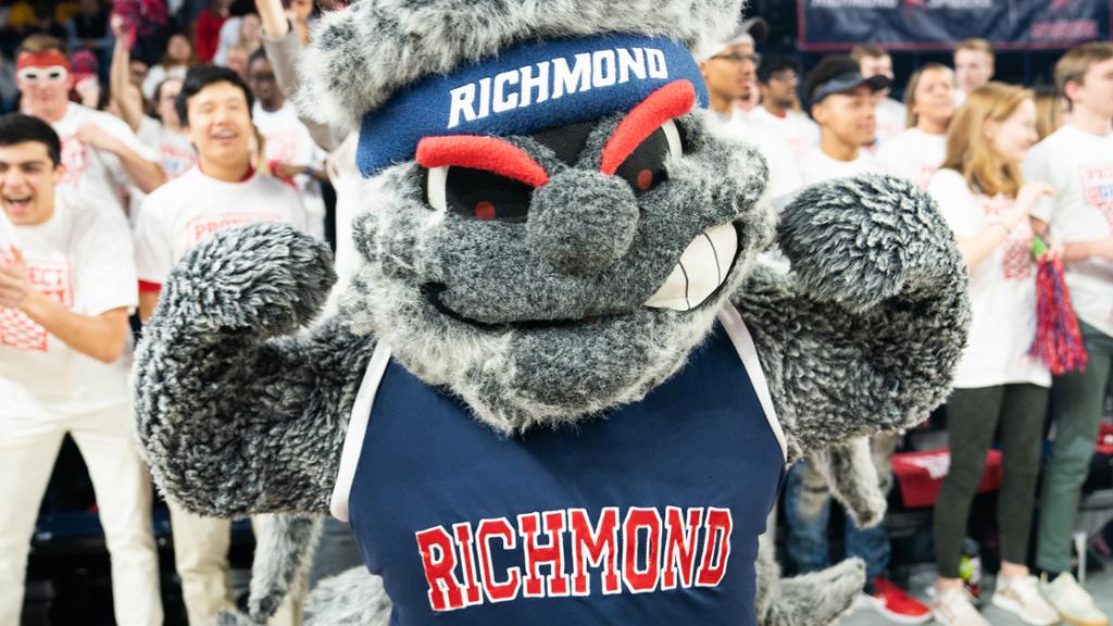 Spider mascot Webstur posing in front of a cheering crowd.