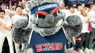Spider mascot Webstur posing in front of a cheering crowd.